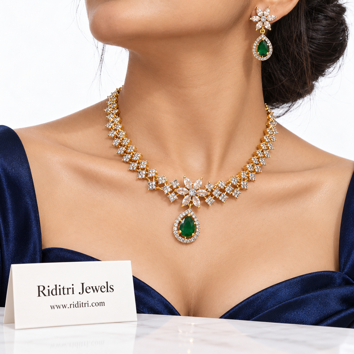 Close view of emerald green teardrop pendant with halo of white stones