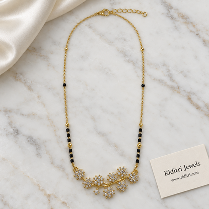 Black bead mangalsutra chain with gold beads and diamond-look flower vine pendant
