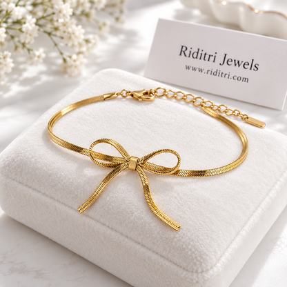 Anti tarnish stainless steel gold bow bracelet with flat herringbone chain tied in a bow and adjustable extender by Riditri