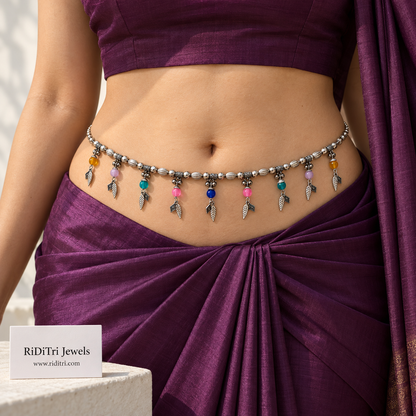 Multicolour leaf charm silver-toned waist belt (kamarbandh) by Riditri with colourful stones and ghungroo bells