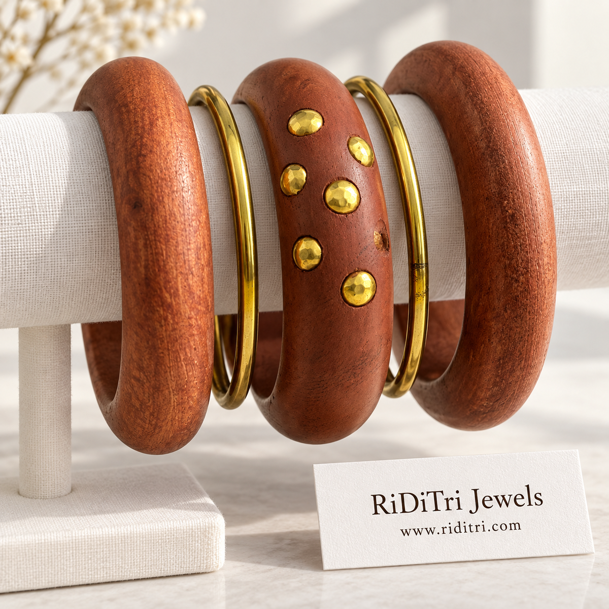 Aranyani bangle set of 5 with a chunky studded wooden bangle, two smooth rounded wooden bangles and two slim gold-toned bangles by Riditri