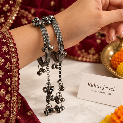 Oxidised ghungroo latkan bangles pair worn on the wrist, dark metal bangles with ghungroo clusters and hanging latkan chains by Riditri