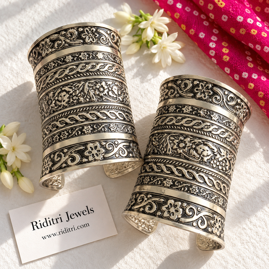 Rajwadi adjustable broad cuff bracelets pair with rows of embossed flowers, vines and twisted rope bands in oxidised finish by Riditri