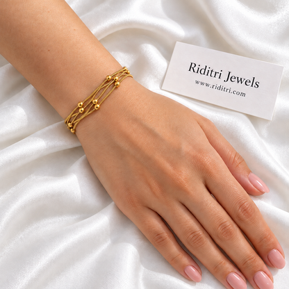 Anti Tarnish Triple Layer Bead Bracelet worn on the wrist – layered gold-toned chains with polished beads, view 2