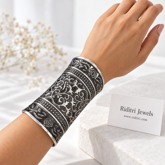 Bel Buta adjustable broad cuff bracelets pair with embossed vine and leaf work, dotted bands and black-and-silver oxidised finish by Riditri
