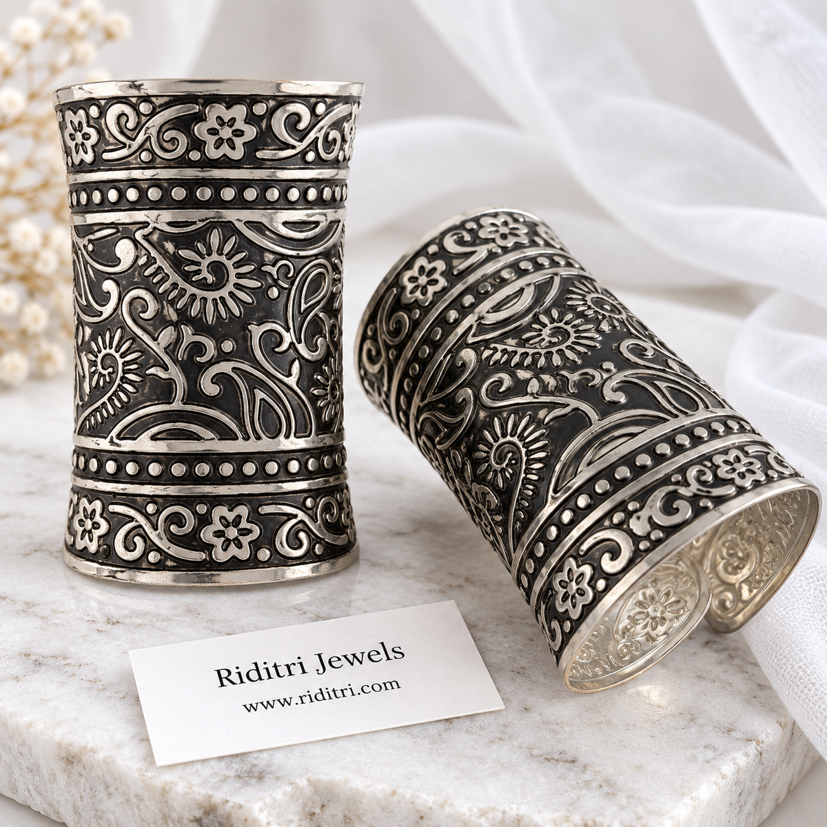 Kairi paisley adjustable broad cuff bracelets pair with embossed paisley, sunflower and vine work in black-and-silver oxidised finish by Riditri