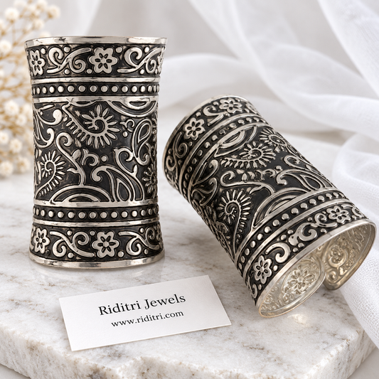 Kairi paisley adjustable broad cuff bracelets pair with embossed paisley, sunflower and vine work in black-and-silver oxidised finish by Riditri