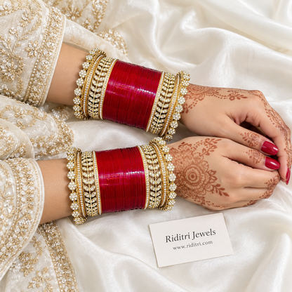 Red Bridal Chooda Set – both hands displayed on an ivory bangle stand, gold-toned stone kadas and flower-edge borders, view 2