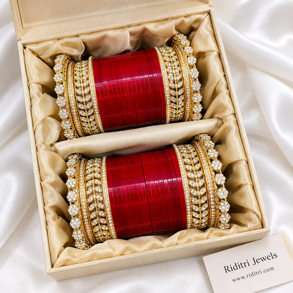 Red bridal chooda set for both hands with glossy red bangles and AD stone leaf kadas, worn with mehendi by Riditri