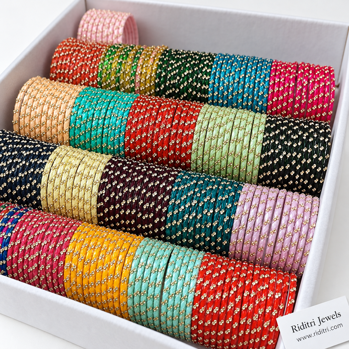 Rows of multicolour glass bangles with sparkling stone work in red, pink, mint, yellow and navy
