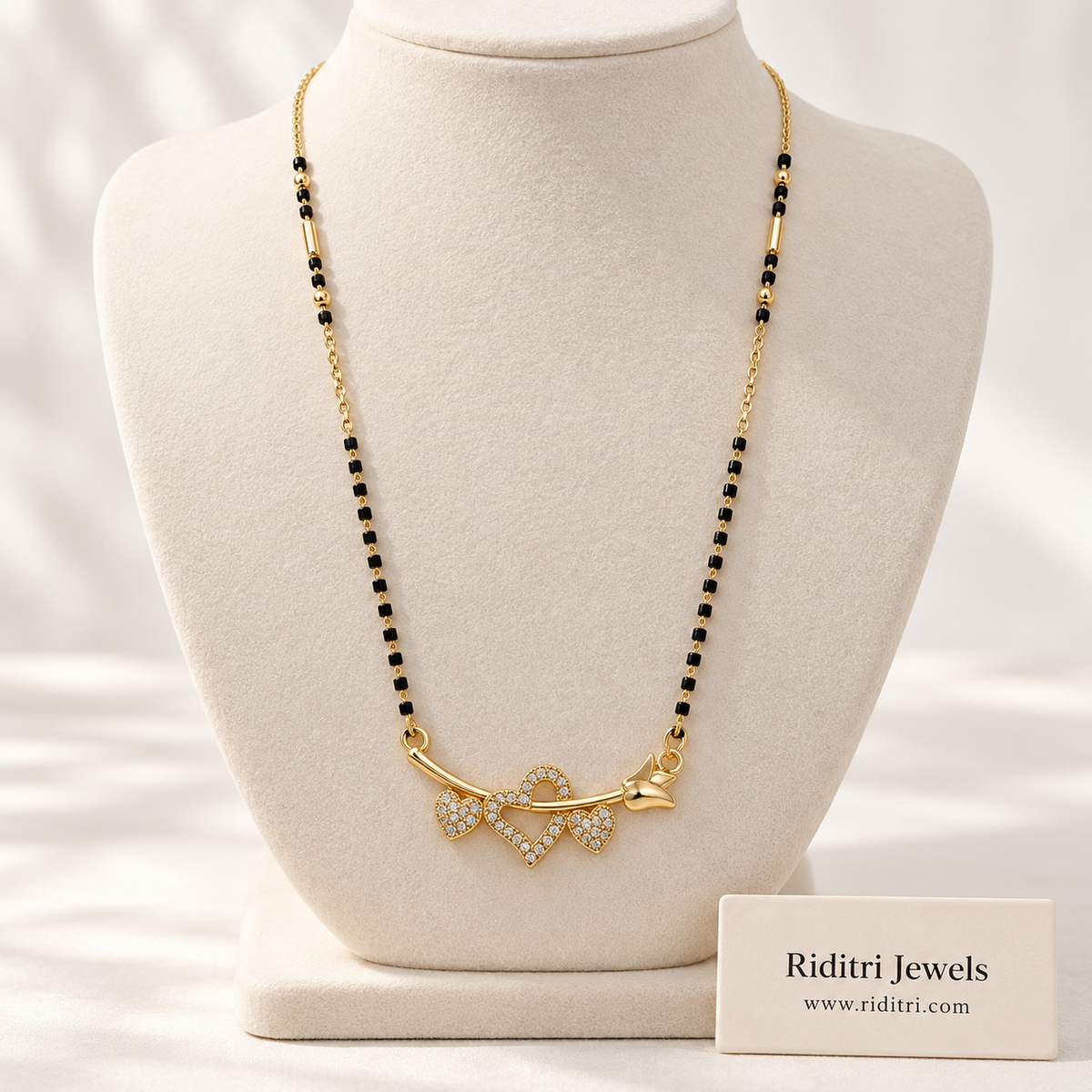 Gold-toned heart mangalsutra pendant with twin stone hearts and leaf vine