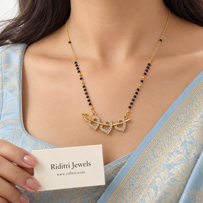 Gold-toned mangalsutra pendant with three open stone hearts on a leaf vine