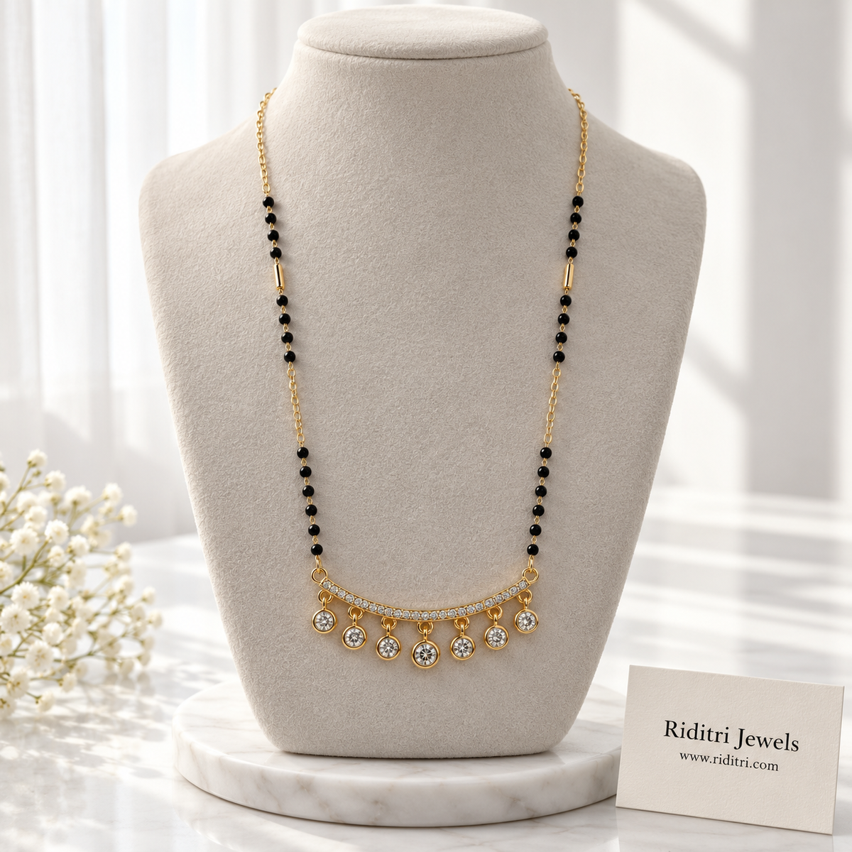 Gold-toned mangalsutra pendant with round bezel-set stone drops swinging below a stone bar