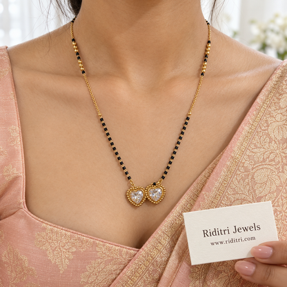 Black bead mangalsutra chain with polished gold beads and twin heart pendant