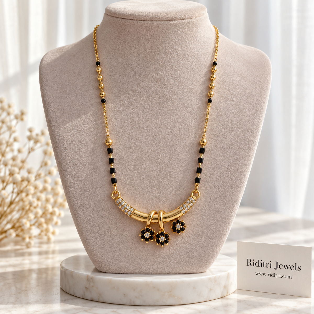 Gold-toned bar mangalsutra pendant with black flower charms and white stone accents