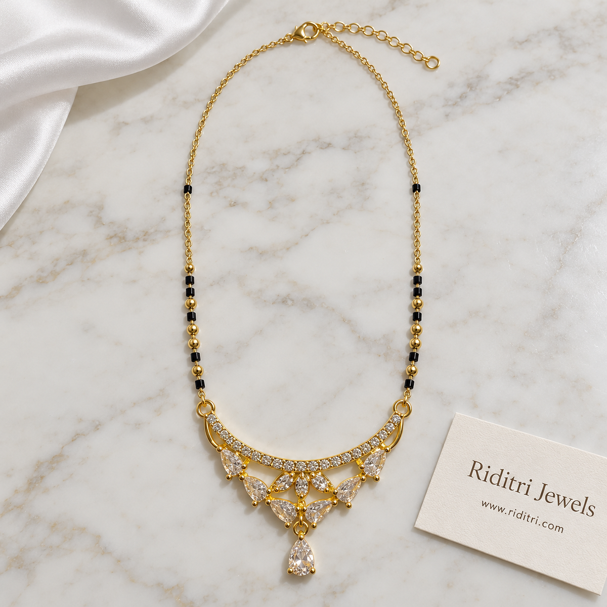 Gold-toned crescent mangalsutra pendant with pear-cut stones and stone flower