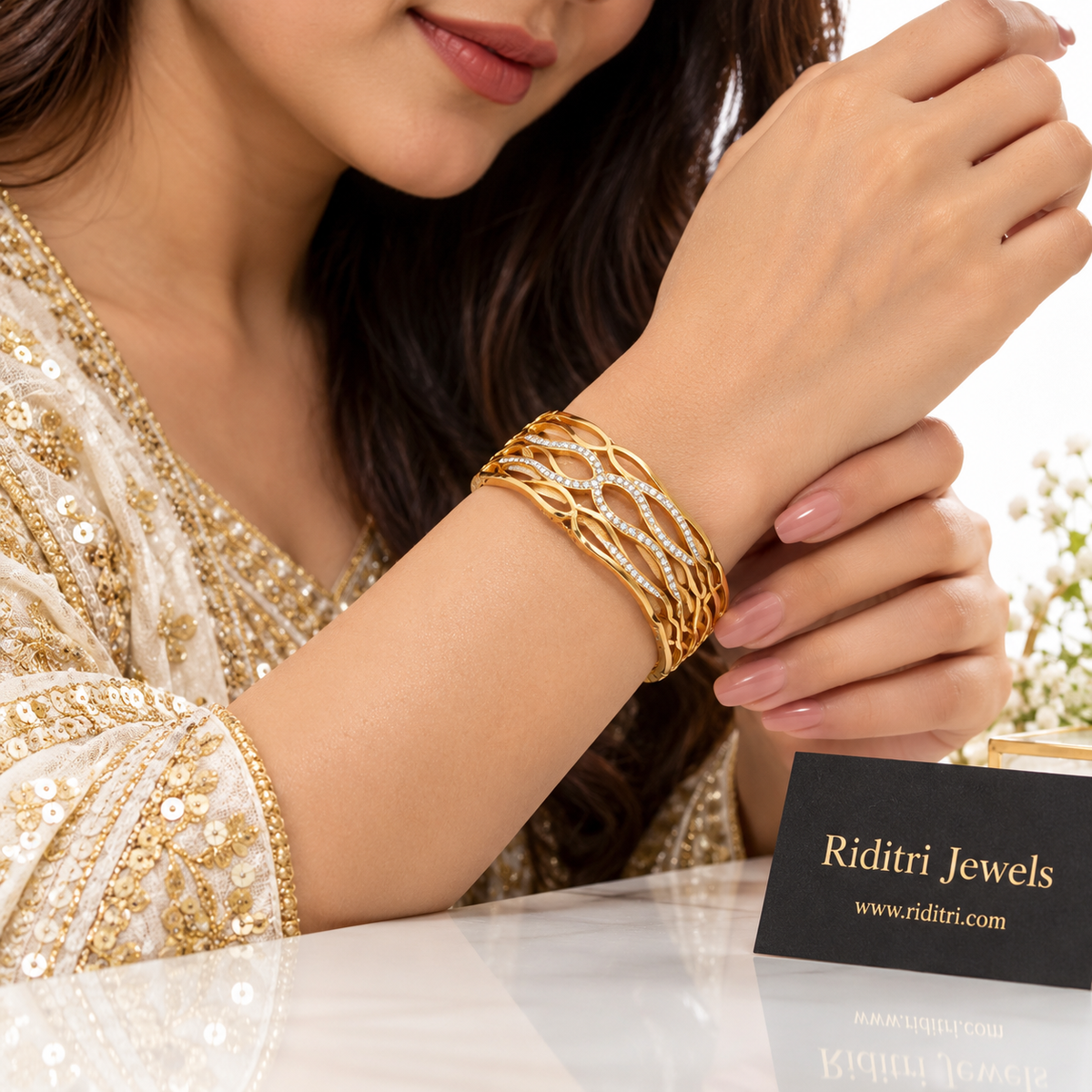 Woman wearing Aura Defined gold-toned bracelet with ivory sequinned ethnic outfit